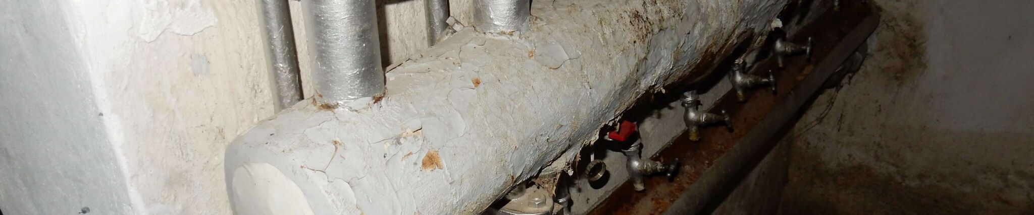 Das Bild für den großen Asbestschein zeigt Rohrleitungen, die eine Sanierung brauchen.